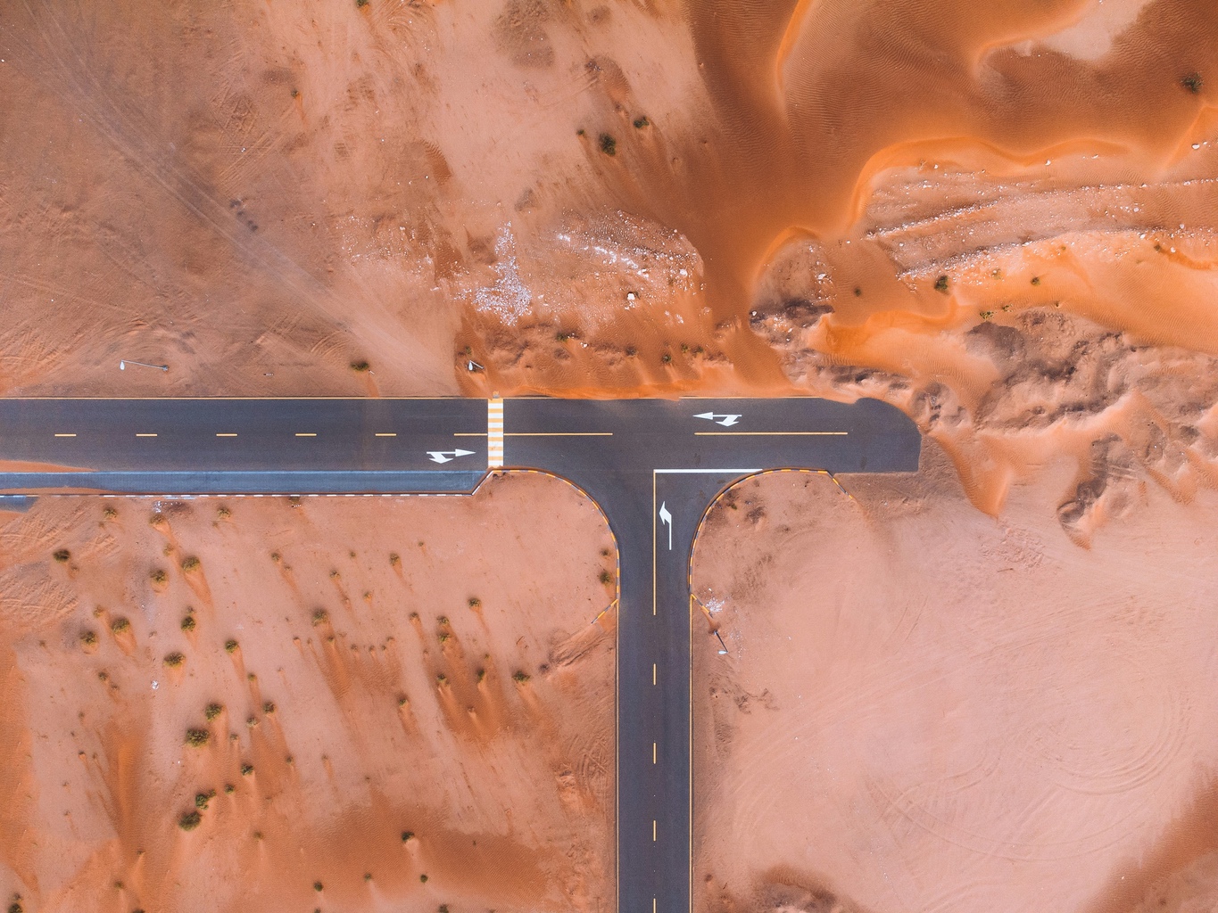 An aerial view of a road intersection in the middle of a desert